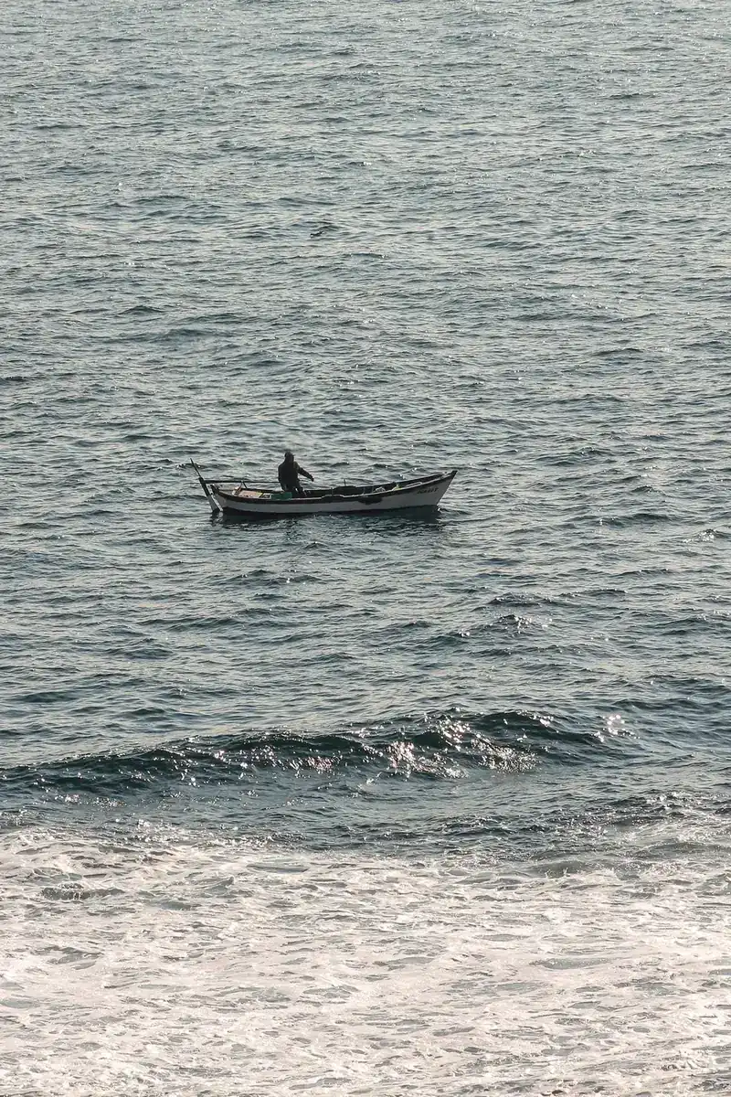 A small nearshore fishing boat moves across open water