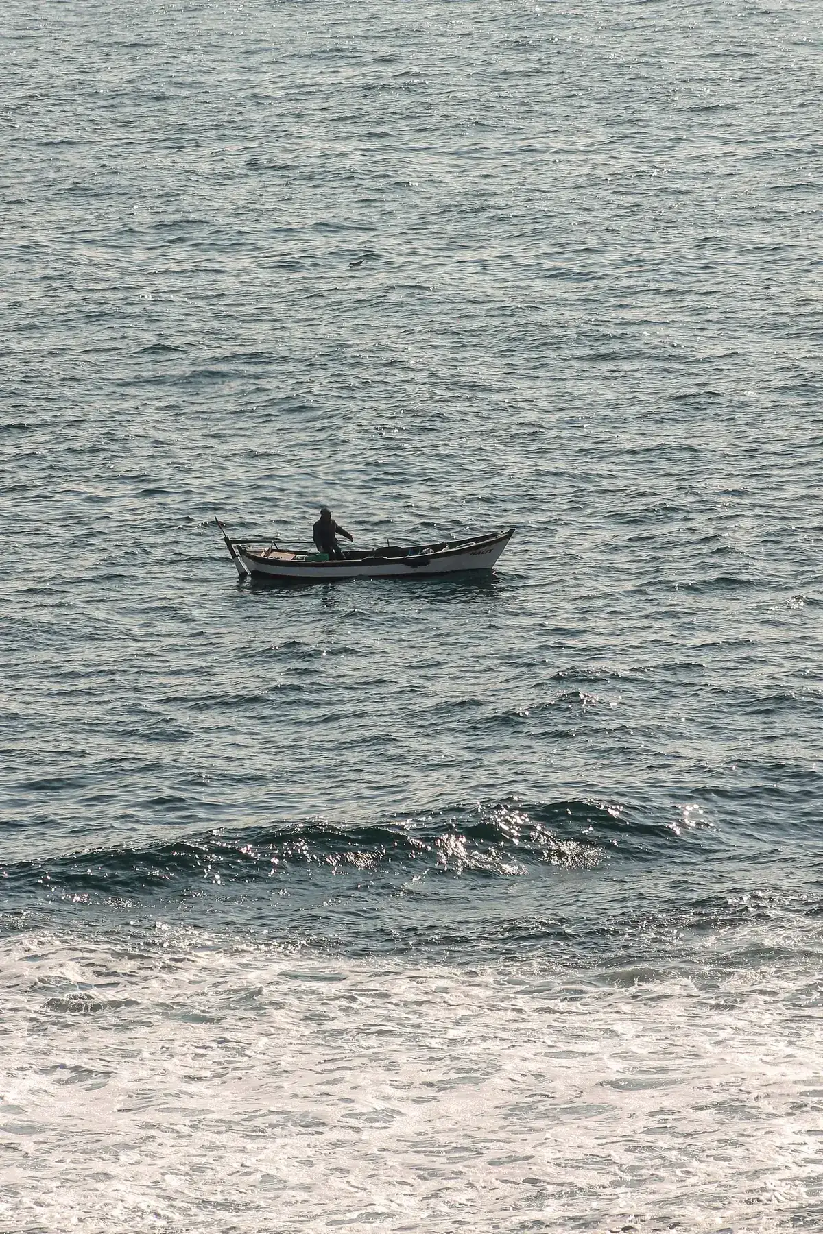 A small nearshore fishing boat moves across open water